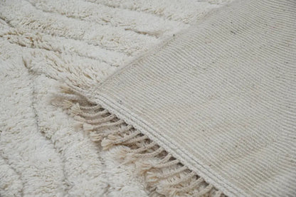 Cream-colored plush wool beni ouarain rug with textured ribbed border and fringed edge moroccan handmade decorbites