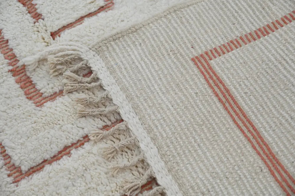 Cream-colored moroccan handmade beni ouarain rug with terracotta geometric patterns and fringed edge 302 x 200 cm