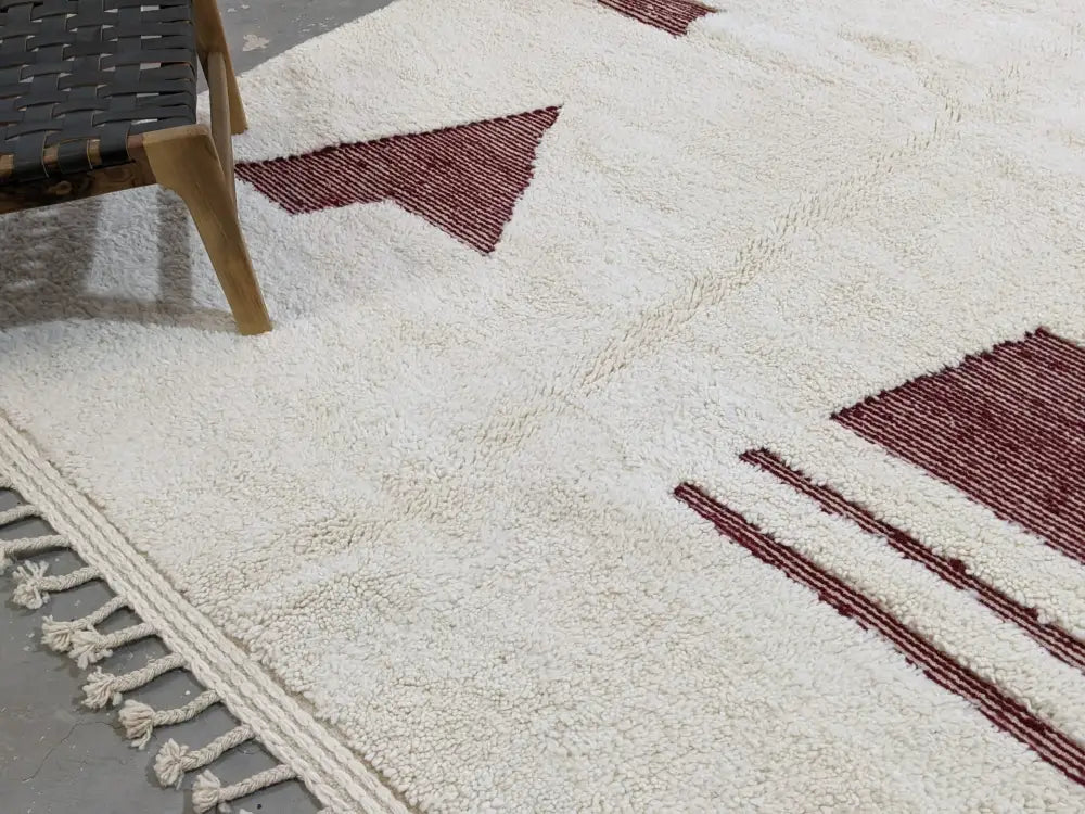 Cream-colored moroccan handmade beni ouarain rug with bold maroon geometric patterns and fringed edge 303 x 214 cm
