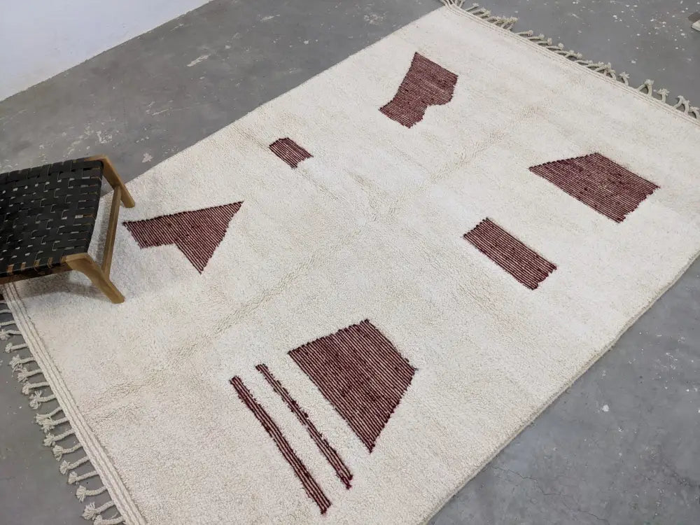 Cream-colored wool beni ouarain rug with geometric maroon patterns and fringed edges moroccan handmade decorbites
