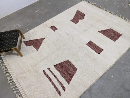 Cream-colored wool beni ouarain rug with geometric maroon patterns and fringed edges moroccan handmade decorbites