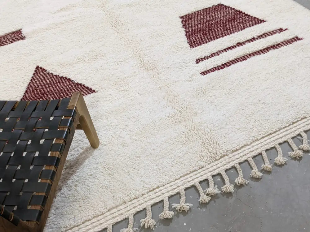 Cream-colored moroccan handmade beni ouarain rug with maroon geometric patterns and fringed edge 303 x 214 cm