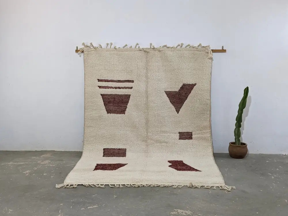 Beige moroccan handmade beni ouarain rug with rust geometric patterns and fringed edges from decorbites