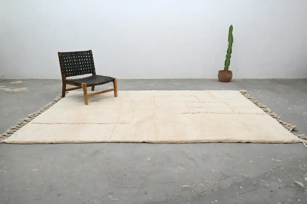 Cream-colored handwoven wool beni ouarain rug with fringed edges and geometric patterns 307 x 205 cm by decorbites