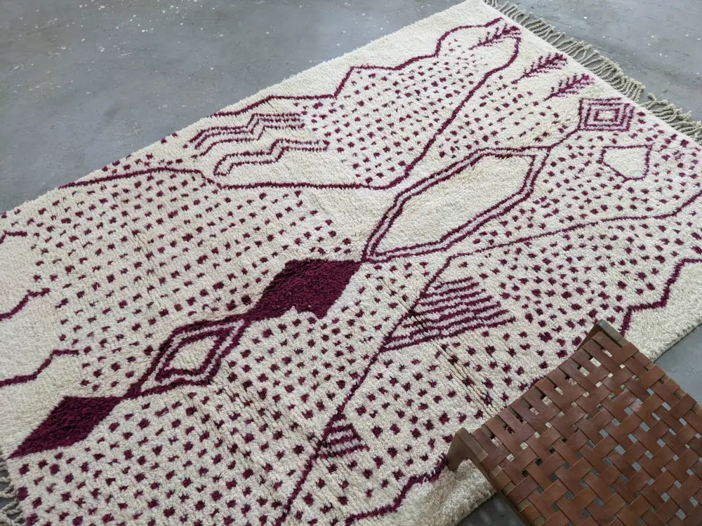 Decorbites™ cream-colored beni ouarain rug with deep burgundy geometric patterns and fringed edges 307 x 213 cm