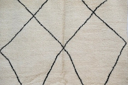 Cream-colored beni ouarain rug with bold black geometric diamond patterns moroccan handmade wool decorbites