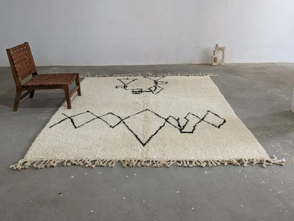 Cream-colored moroccan handmade beni ouarain rug with black geometric patterns and fringed edges 310 x 210 cm