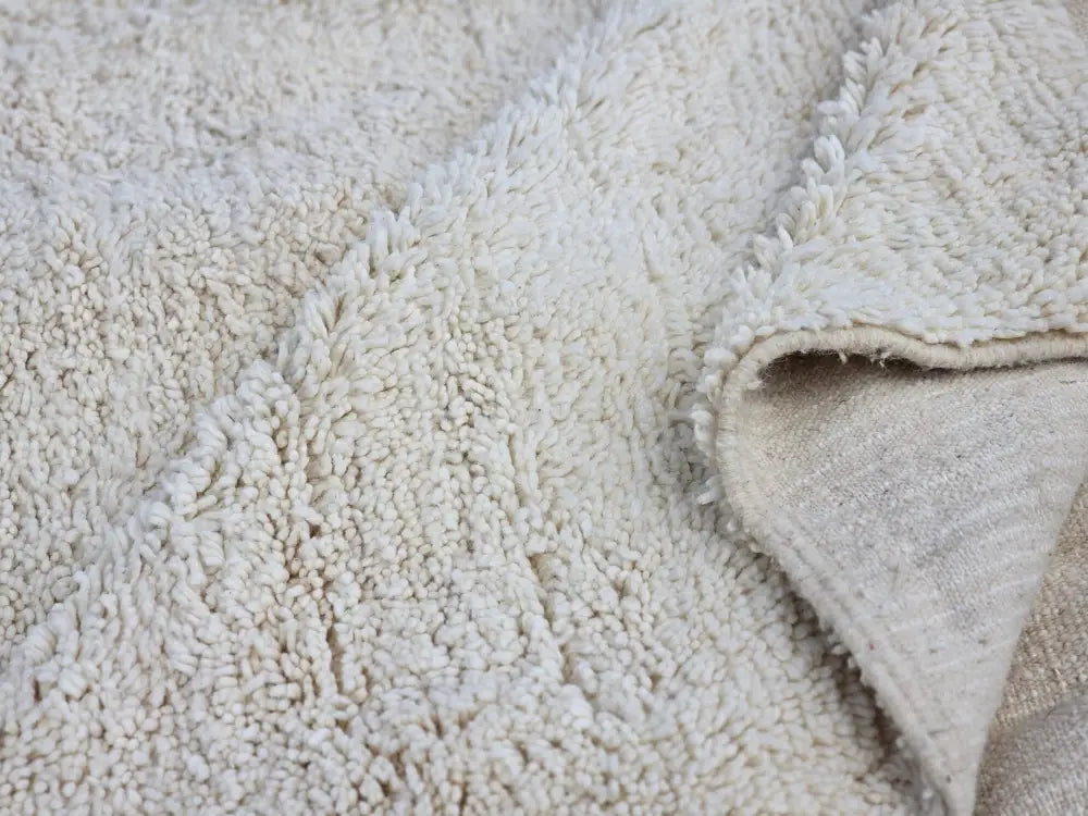 Cream-colored plush fleece blanket with soft textured surface and lining in moroccan handmade beni ouarain rug design