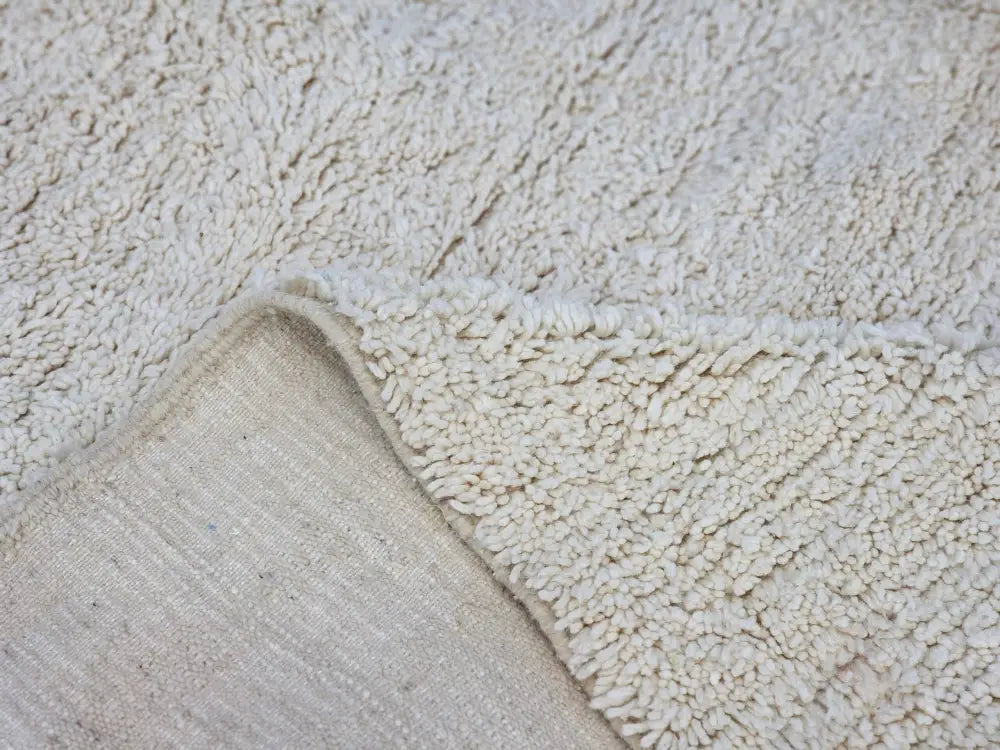 Cream-colored plush shaggy beni ouarain rug with soft textured surface and visible woven backing moroccan handmade