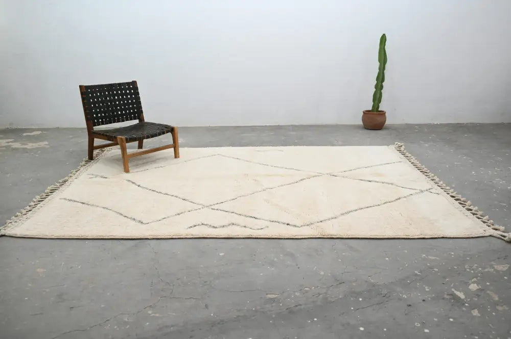 Cream-colored moroccan handmade beni ouarain rug with black geometric stitching and fringed edges 303 x 212 cm