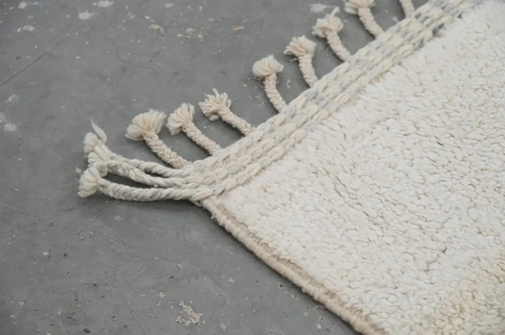 Cream-colored moroccan handmade beni ouarain rug with plush texture and fringed twisted cotton rope edge 303 x 212 cm