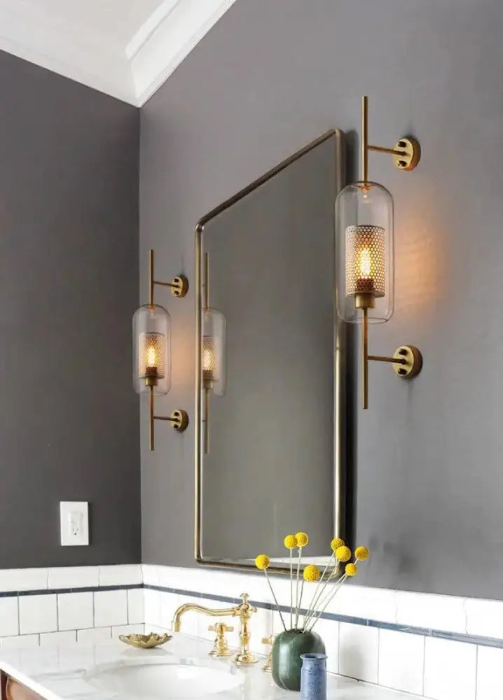 Decorbites™ brass-finished bathroom wall sconce with perforated clear glass shades for modern bathroom wall lighting