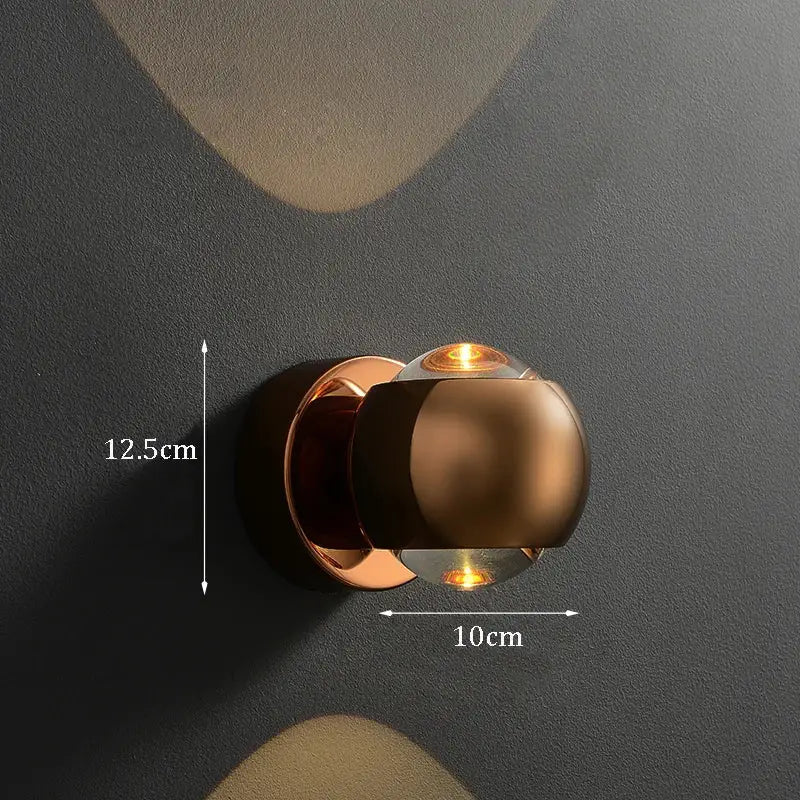 Modern copper-toned brass led wall sconce with sleek spherical design and warm amber light for indoor lighting