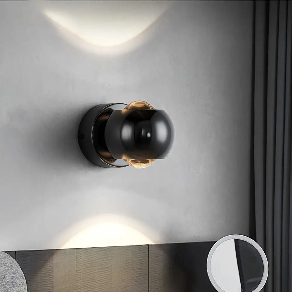 DecorBites Moroccan modern black brass led wall lamp with a black spherical sconce and warm amber glass globe