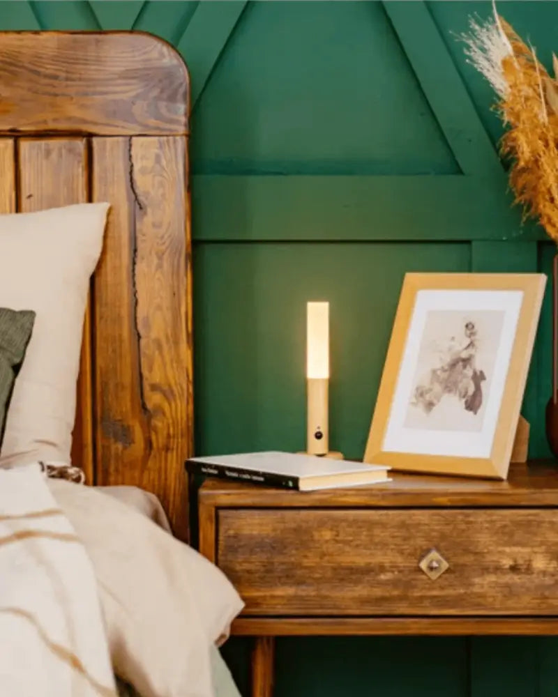 A sleek wooden bedside table with a diamond brass handle beside a DecorBites™ moroccan rechargeable battery wall sconce