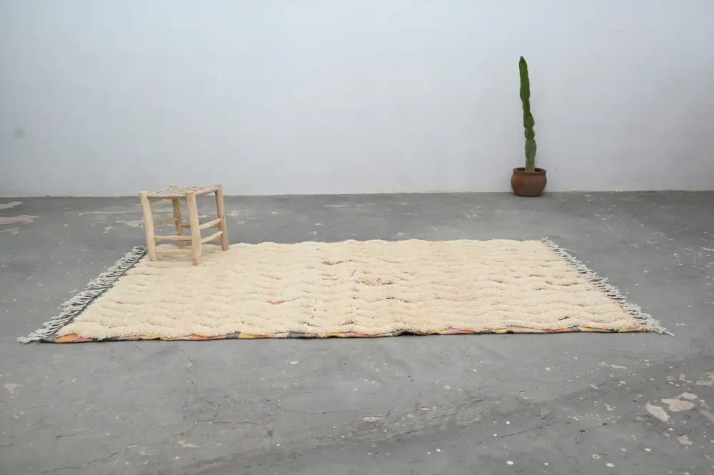Cream-colored handmade traditional azilal rug with textured wool and fringed edges by decorbites 240x147cm