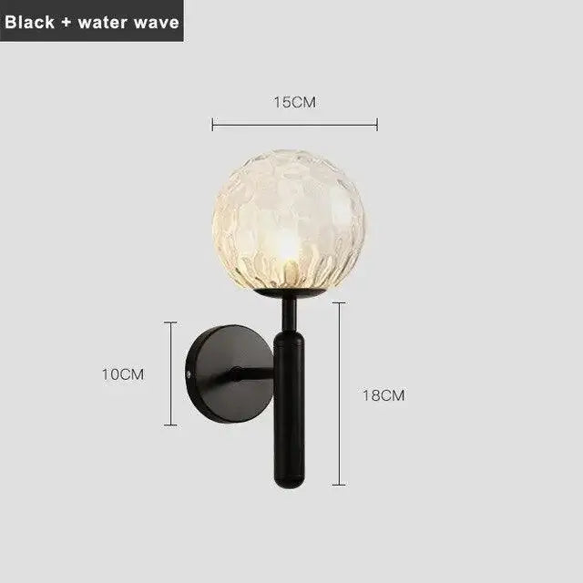 Black metal mynte wall sconce with textured translucent glass globe featuring intricate water wave pattern by decorbites