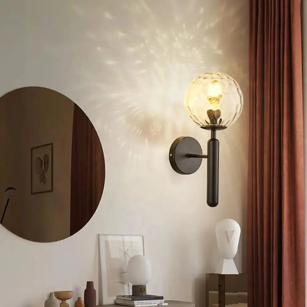 A decorbites™ mynte wall sconce with a textured frosted glass globe and matte black metal arm for modern lighting