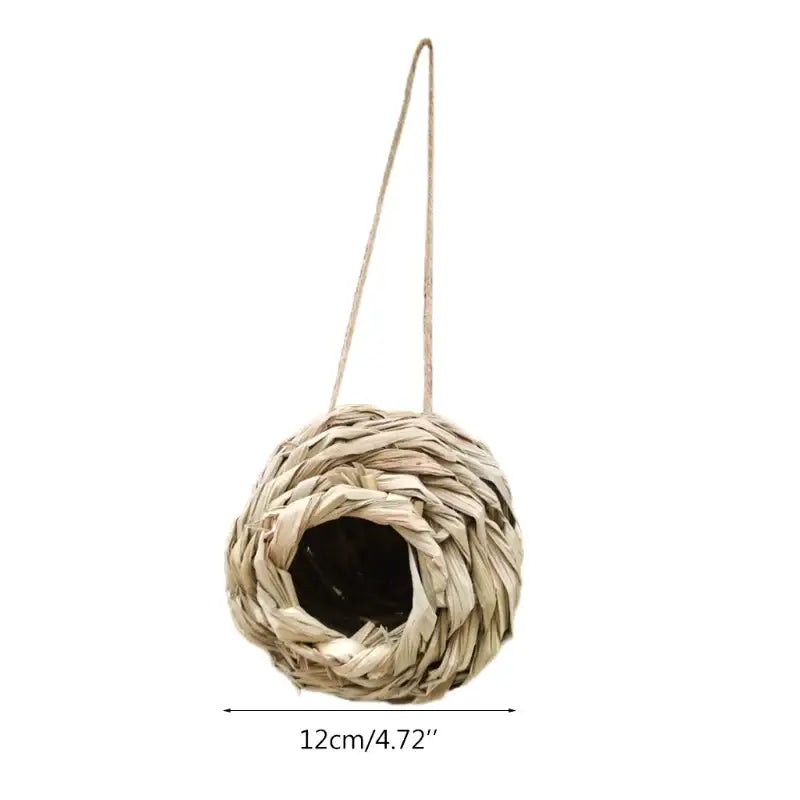 Beige hand-woven natural grass bird cage with hanging rope designed as a parrot nest by DecorBites