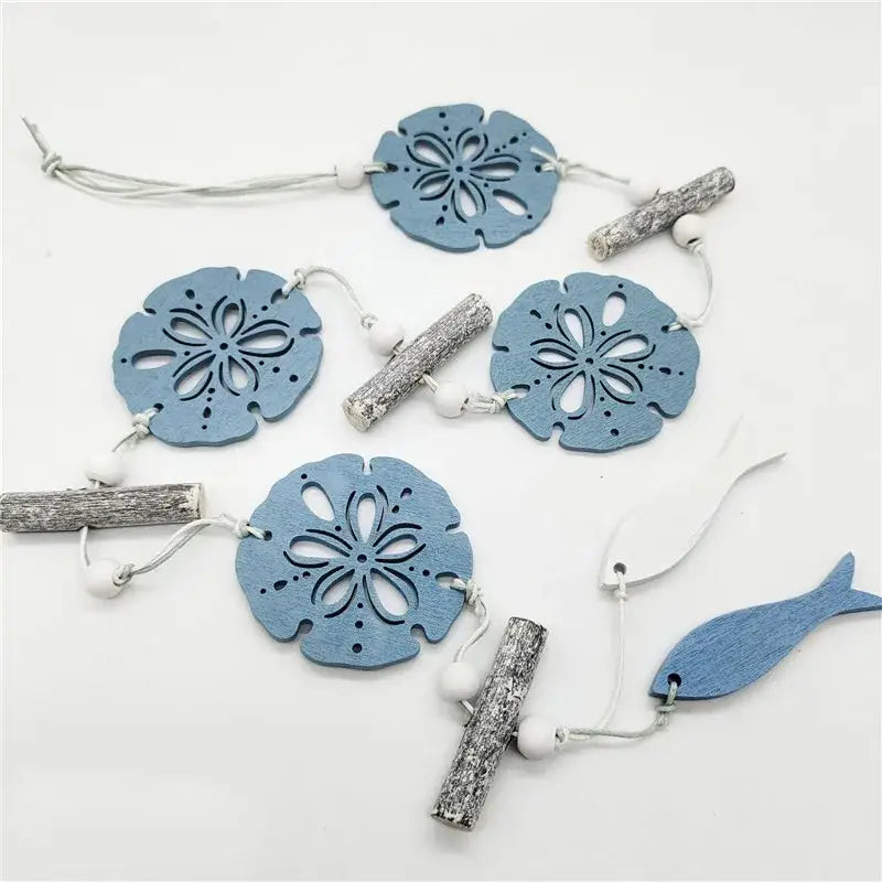 Blue sand dollar wooden ornaments with intricate cutouts accented by silver driftwood and beads for nautical theme wall decor