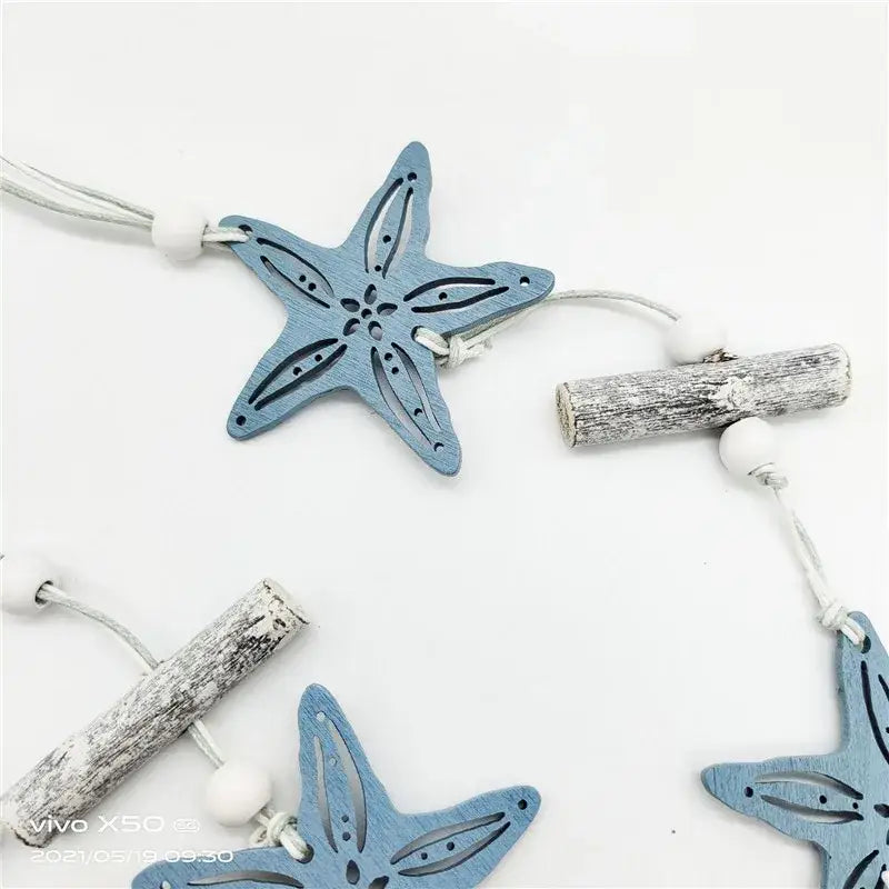 Decorbites™ nautical theme wall decor featuring blue wooden starfish ornaments with cut-out patterns and fishing net design