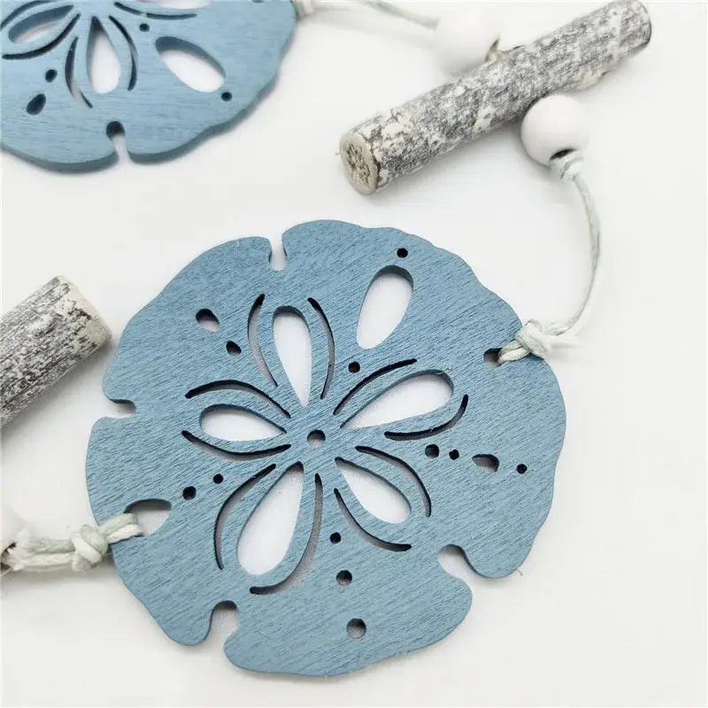 Light blue wooden sand dollar ornament with weathered finish and intricate cut-outs for nautical theme wall decor fishing net decoration