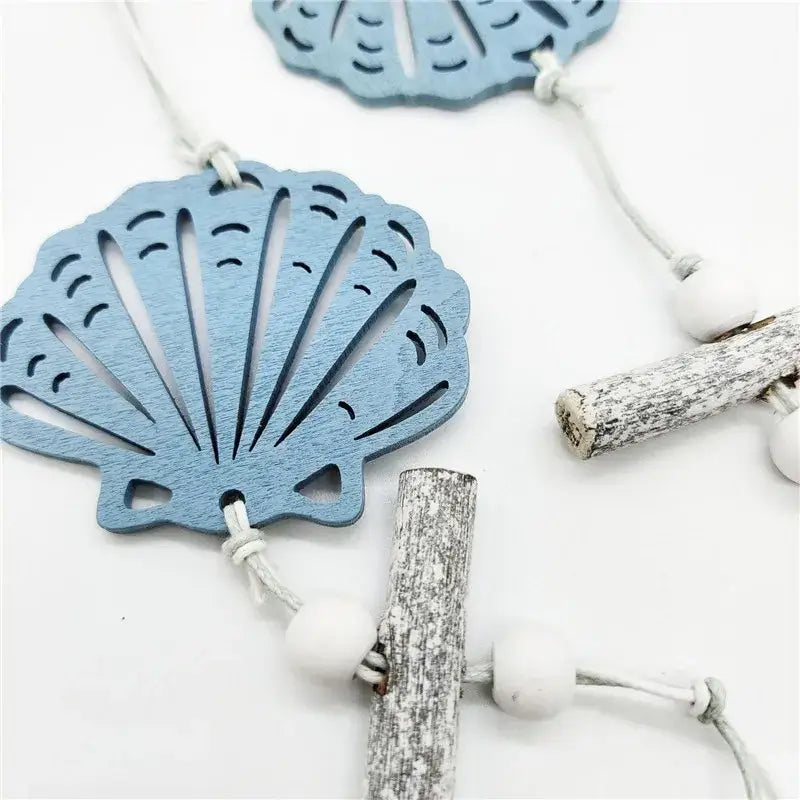 Light blue wooden shell-shaped ornament with cut-out details and rustic string for nautical theme wall decor fishing net decoration