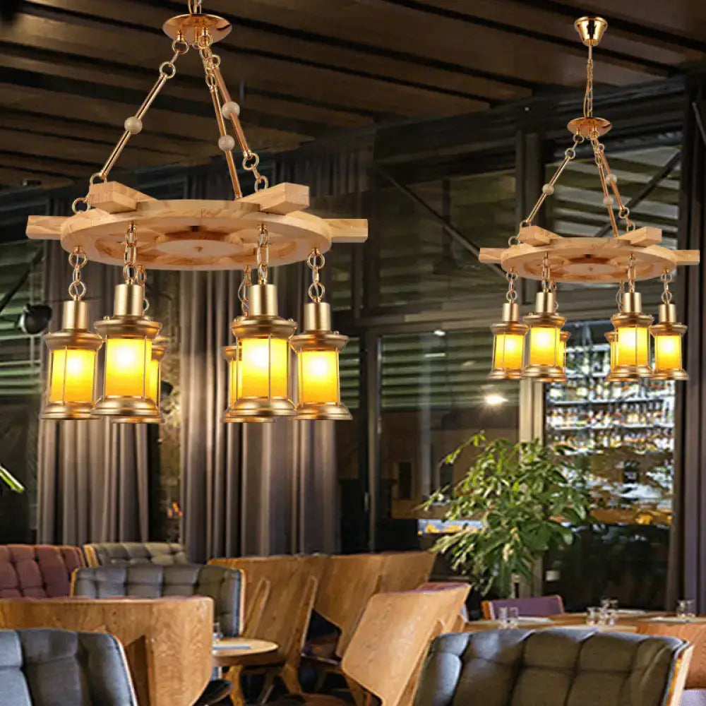 Decorbites™ noemi industrial pendant chandelier with rustic wood spool and brass lanterns with warm yellow lighting