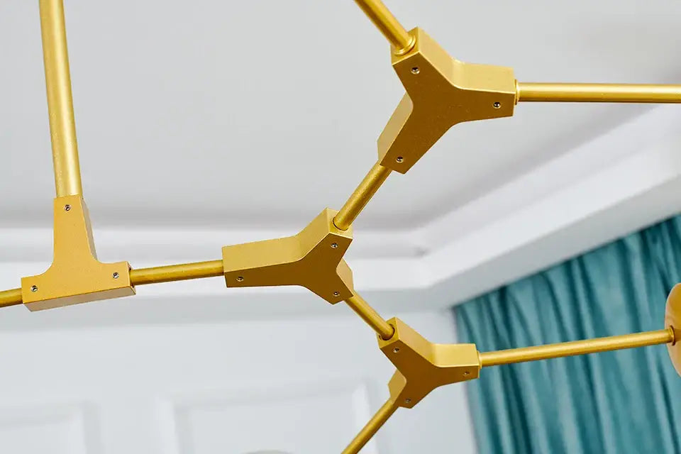 Gold-colored geometric DecorBites™ nordic chandelier with angular tripod connectors and cylindrical rods for living rooms