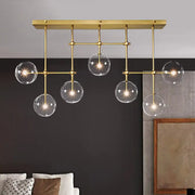 Modern brass ceiling light with five clear glass globes suspended from a geometric frame 220v-240v