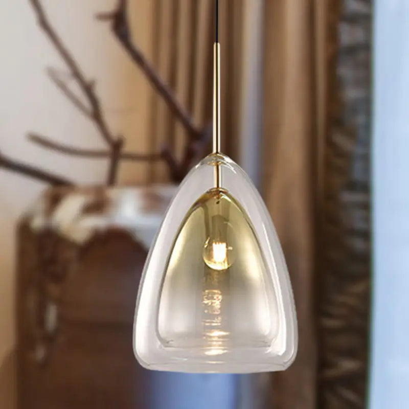 DecorBites™ Nordic pendant light fixture with a clear teardrop glass shade and gold-toned metal stem in champagne finish