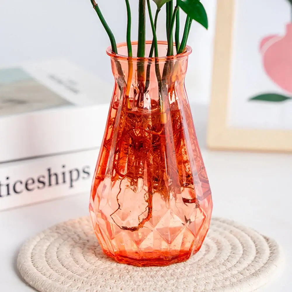 A translucent coral-colored glass nordic flower vase with a faceted geometric design for modern home decor