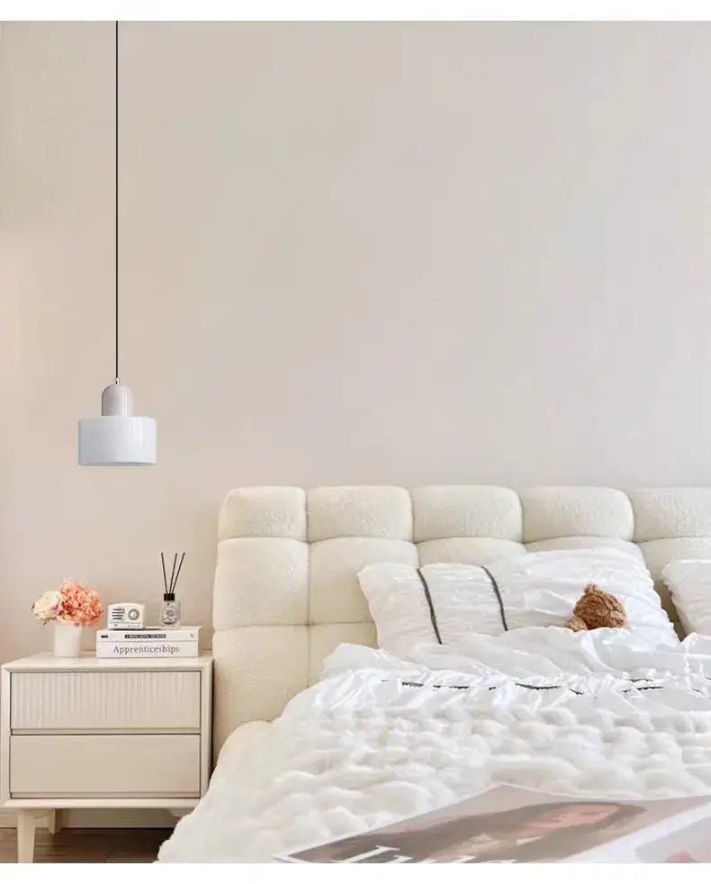Cream-colored tufted headboard with plush texture and black piping shown with decorbites™ nordic glass chandelier for bedroom
