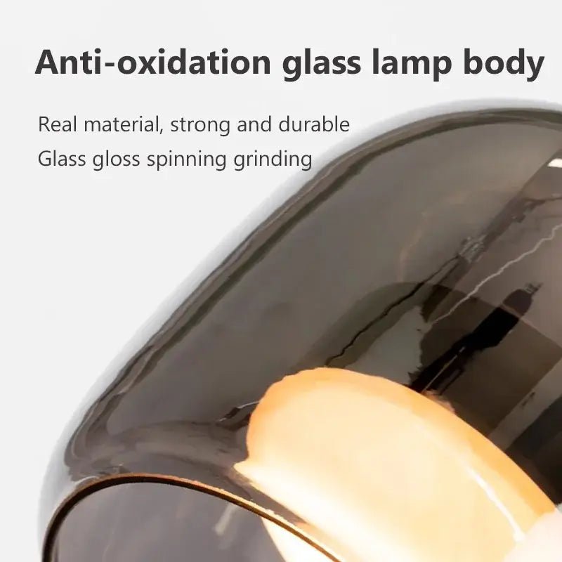 A sleek dark-tinted nordic glass led pendant chandelier with a glossy finish and smooth curves by decorbites