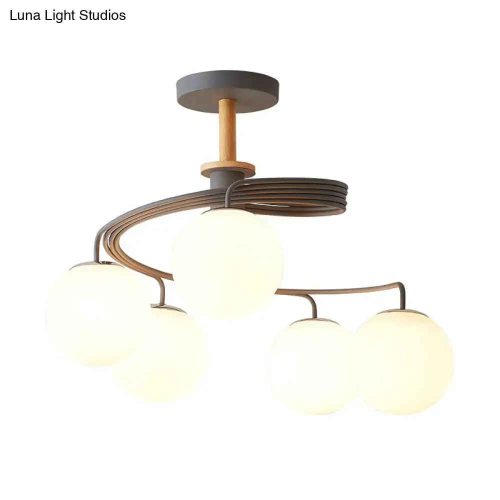 Decorbites nordic iron swirl flush chandelier with 5 orb glass shades suspended on a grey metal frame with wood downrod