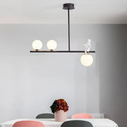 Black modern nordic island pendant light with three opaline glass shade bulbs and a white figurine on the central bar