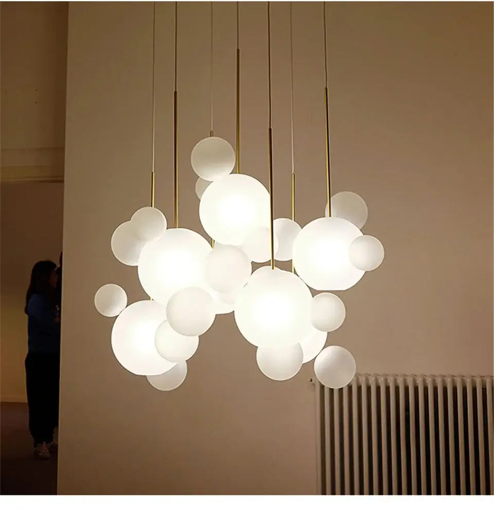 A modern decorbites nordic led bubble chandelier with frosted white spherical bulbs and gold-toned rods for home lighting