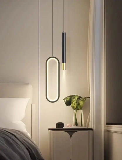 Modern black and gold DecorBites™ Nordic led pendant lights with sleek oval designs hang above a bedside table