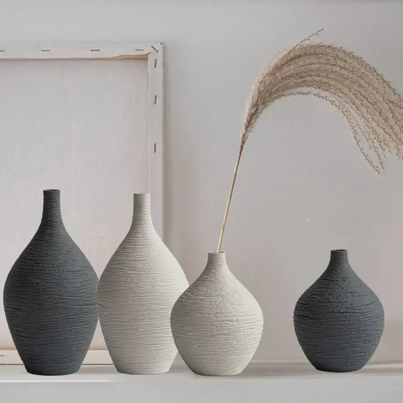 Set of four nordic luxury ceramic vases in matte gray and off-white with textured ribbed surfaces for home décor