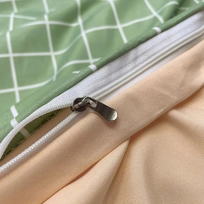 A silver-toned zipper with a metallic pull tab on a light green nordic plaid cotton bedding set from decorbites