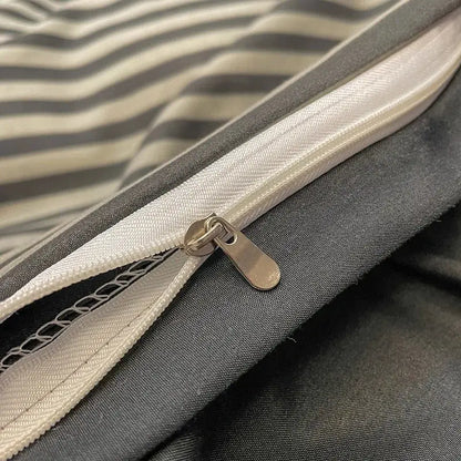 Silver-toned zipper with metallic pull tab on gray and white striped fabric of decorbites nordic plaid cotton bedding set