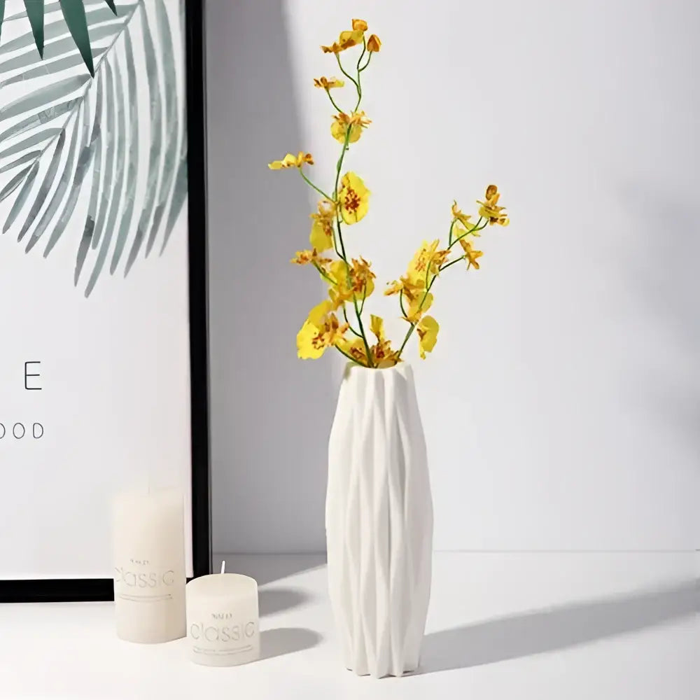 White ceramic nordic plastic vase with vertical ridges holding yellow orchids for modern home decor