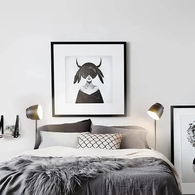 Black-framed monochrome artwork of a woman with horned headwear featured in DecorBites™ nordic plug-in wall sconce wall light