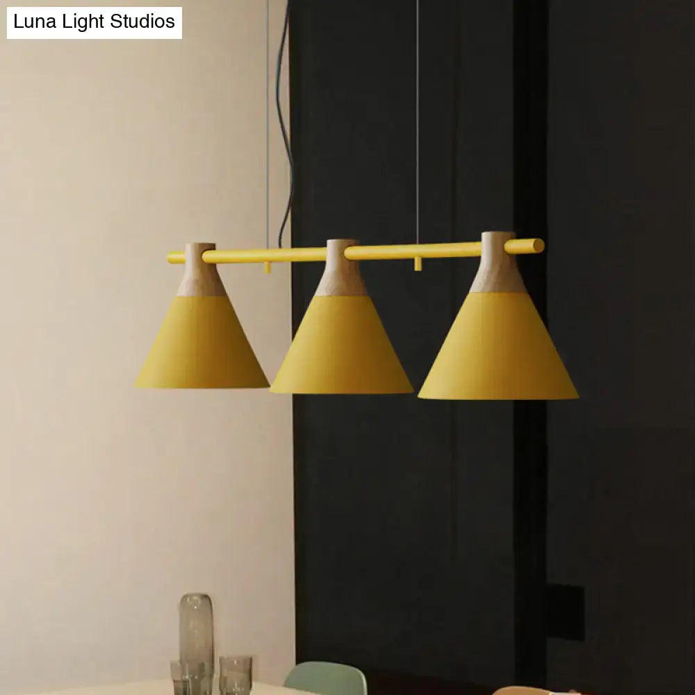Yellow nordic style pendant light with three conical metal shades and wooden accents hanging from adjustable chain cord length bar
