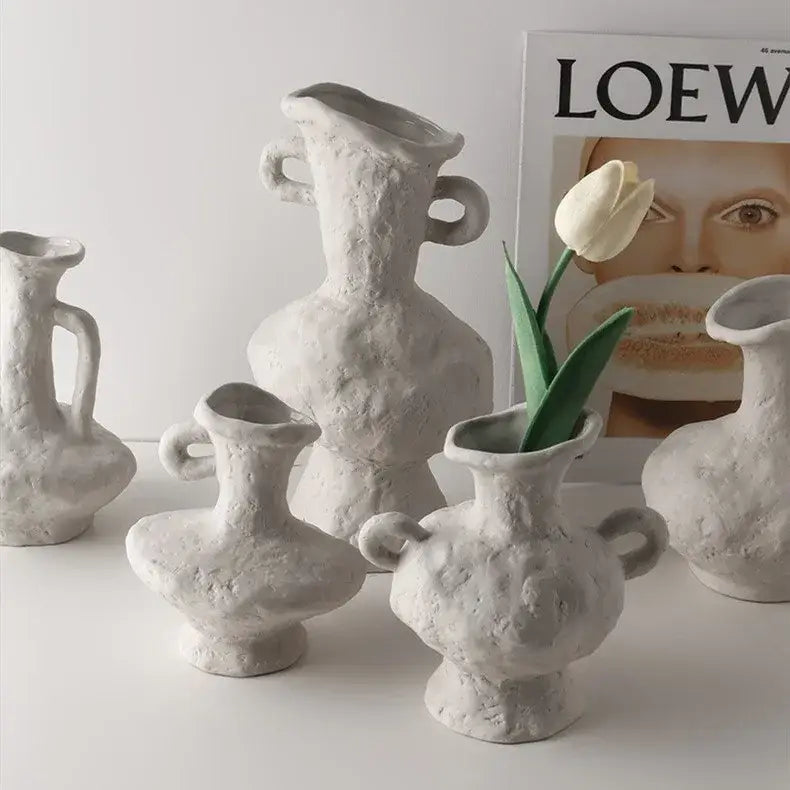 A collection of off-white nordic style ceramic flower pots with textured surfaces and varied shapes and handles