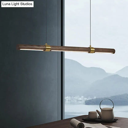 Modern minimalist wood island pendant with wooden barrel body and polished brass accents for dining table lighting