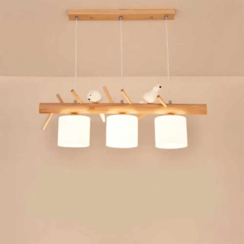 DecorBites Nordic wood pendant light with three white opal glass cylinders and resin bird decor on wooden beam