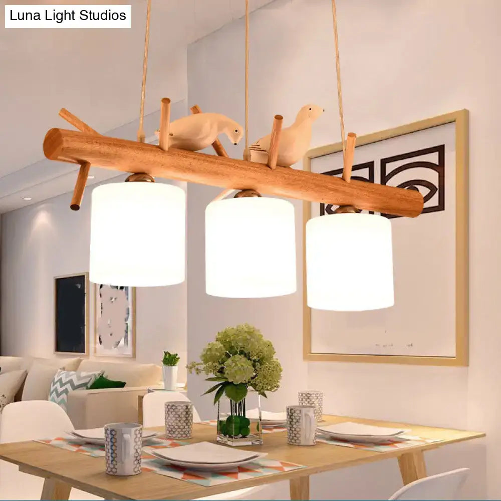 DecorBites™ nordic wood pendant light with three white opal glass cylinder shades and resin bird decor accents