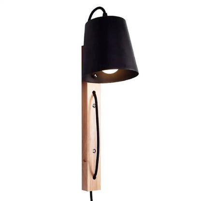Black metal wall sconce with plug in design mounted on light wood plank featuring black cord detail from DecorBites Nordic Wood line