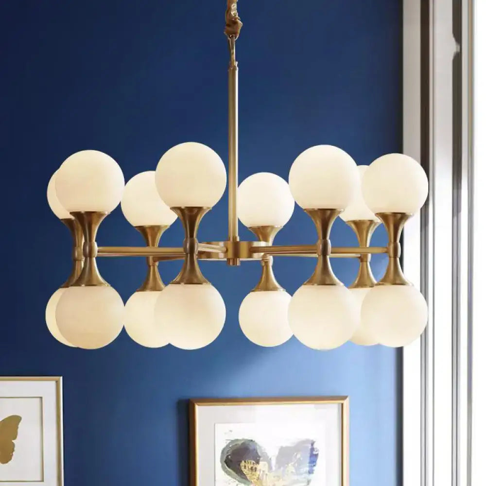 Brass-finished DecorBites™ opal glass chandelier light with 12/16 frosted globe heads in postmodern design